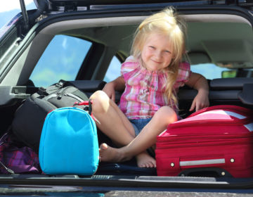 travel young girl portrait at the car trunk